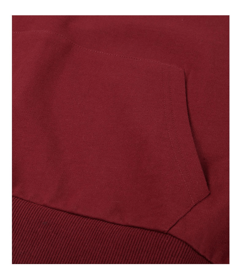 Close-up of a solid burgundy women's sweatshirt with a front pocket and ribbed hem, showcasing the cotton blend fabric texture.
